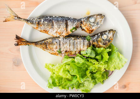 Due appena cucinata sgombri servito con insalata di lattuga con cipolla rossa Foto Stock