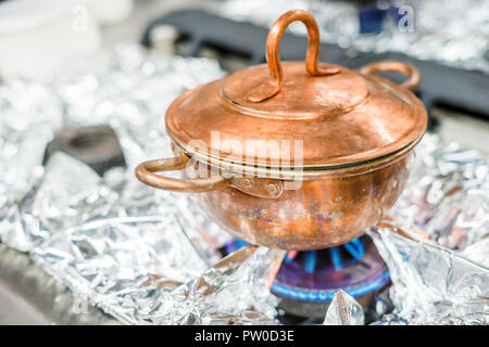 Un bronzo, vintage pentola sul fornello a gas nel ristorante di cucina Foto Stock