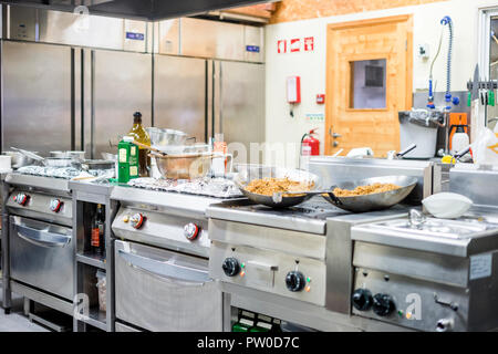 Cucina di interni durante la preparazione di alimenti durante l'ora di pranzo in ristorante Foto Stock