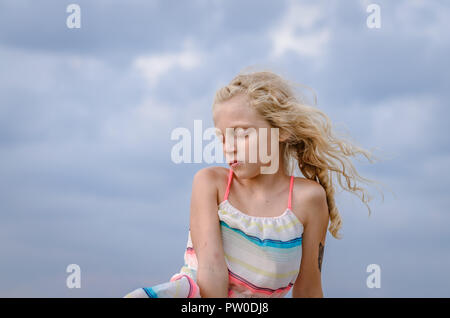 Adorabile bambina con capelli biondi ritratto e cielo blu Foto Stock