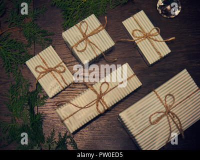 Telaio di natale. Regali di natale, pigne, gypsophila fiori, thuja rami sul bianco sullo sfondo di legno. Appartamento laico, vista dall'alto, spazio di copia Foto Stock