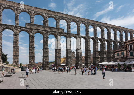 Drammatico, antico acquedotto romano torreggia su plaza in Segovia, deve vedere la meraviglia di ingegneria in Spagna, turisti visitano. Foto Stock