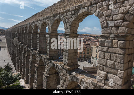 Dramatic arches of ancient Roman Aqueduct towers over plaza in Segovia, a must-see marvel of engineering in Spain, a short train ride from Madrid. Foto Stock
