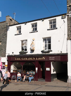 La gente seduta al di fuori del Golden Lion pub in Keswick, Cumbria, England, Regno Unito Foto Stock