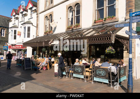 Le persone al di fuori seduta Brysons sala da tè in Keswick centro città, Cumbria, England, Regno Unito Foto Stock