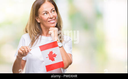 Medioevo donna ispanica holding bandiera del Canada su sfondo isolato faccia seriamente pensando di domanda, molto confusa idea Foto Stock