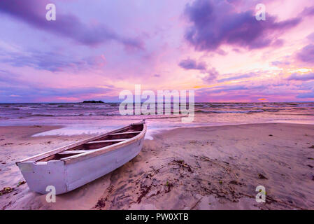 Il lago Malawi tramonto nella spiaggia di Kande Africa, canoa barca sulla spiaggia tranquilla spiaggia vacanza bellissimo tramonto colori blu porpora giallo arancione nel cielo e clou Foto Stock