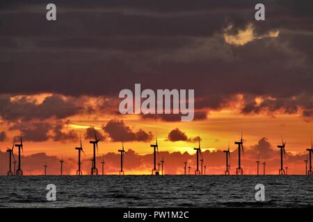 Sunset over Walney per centrali eoliche offshore presi da Westshore Walney Island su la costa del Cumbria Regno Unito. Foto Stock