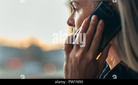 Close up ritratto della coppia business donna più di parlare di telefono cellulare. Vista laterale del senior business donna facendo una telefonata. Foto Stock