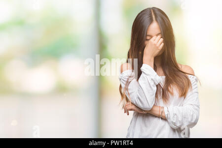 Giovane donna asiatica su sfondo isolato stanco strofinando il naso e gli occhi sensazione di stanchezza e mal di testa. Stress e frustrazione concetto. Foto Stock
