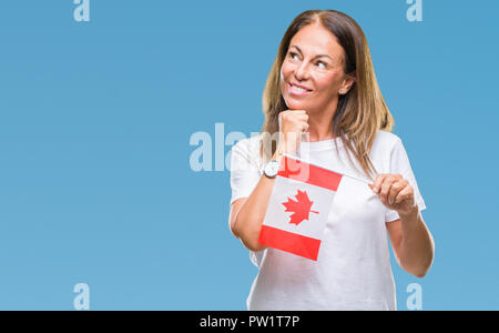 Medioevo donna ispanica holding bandiera del Canada su sfondo isolato faccia seriamente pensando di domanda, molto confusa idea Foto Stock