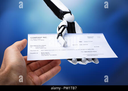 Close-up di mano robotica dando verificare di persona su sfondo blu Foto Stock