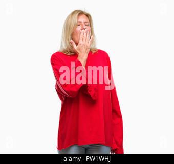 Medioevo donna bionda su sfondo isolato annoiati sbadigli stanchi che copre la bocca con la mano. Inquieto e sonnolenza. Foto Stock