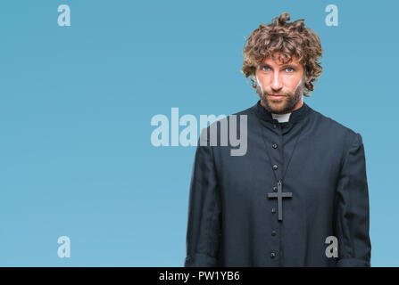 Bello ispanica sacerdote cattolico uomo sullo sfondo isolato premuto e la preoccupazione per la sofferenza, gridando arrabbiato e paura. Triste espressione. Foto Stock