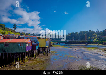 Veduta esterna del coorful belle case in legno su palafitte palafitos, in una bassa marea vista giorno di una splendida giornata di sole a Castro, Isola di Chiloe Foto Stock