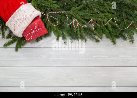 Natale Capodanno piatto decor laici di rami di abete, calza e regalo su nei toni del bianco in legno naturale plank texture di sfondo stile provenzale con spazio di copia Foto Stock