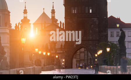 Charles Bridge all'alba: sagome di Old Bridge Tower, le chiese e le guglie della vecchia Praga su un sunrise Foto Stock