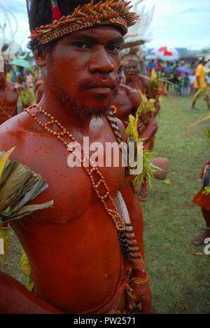 Vestiti in maniera colorata e il volto dipinto di uomo come parte di un cantare cantare in Madang, Papua Nuova Guinea. Foto Stock