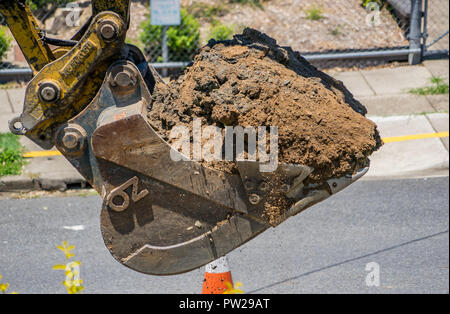 I lavoratori di scavare fino alla strada per stabilire nuove tubazioni Foto Stock