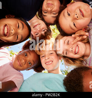 Un huddle di ragazzi in età scolare che guarda la fotocamera, close up Foto Stock