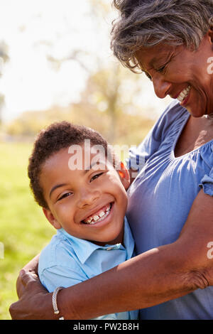 Chiusura del nipote abbracciando la nonna in posizione di parcheggio Foto Stock