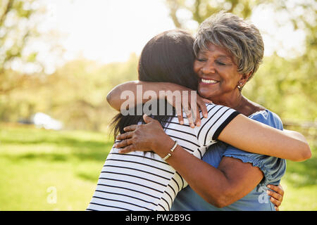 Senior Madre con figlia adulta abbracciando in posizione di parcheggio Foto Stock