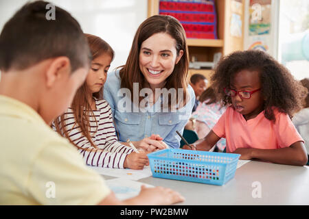 Femmina di insegnante di scuola elementare e i ragazzi in classe, close up Foto Stock