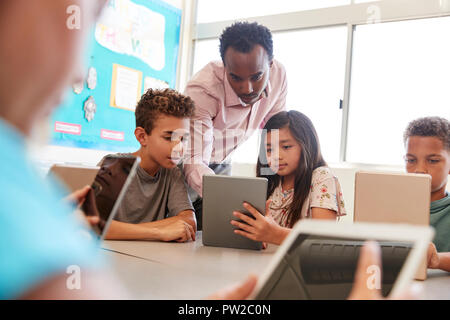 Docente presso la scuola i bambini che utilizzano il computer in classe Foto Stock