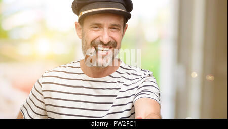 Sailor capitano uomo il fumo di tabacco contiene tubo mani accogliente nella posa di handshake, esprimendo la fiducia e il concetto di successo, saluto Foto Stock