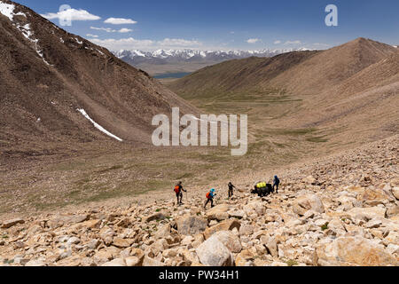 Escursionisti scendono da 4,800m Bel Airyk Pass con Zorkul Lago in background su trek da Keng Shiber di Kara Jilga, Pamir Mountains, Tagikistan. Foto Stock