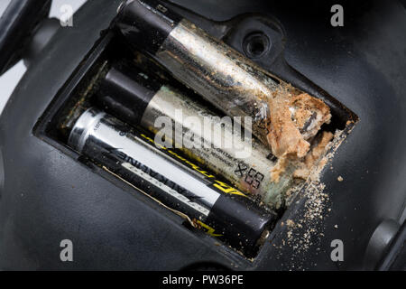 Un metallo alcalino Batteria AAA che è stato lasciato per diversi anni in una coppia di audizione elettronico difensori e disgiunto dal terminale negativo della batteria Foto Stock