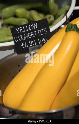 Pila di giallo le zucchine in vendita su un mercato degli agricoltori nel Kent, Regno Unito Foto Stock