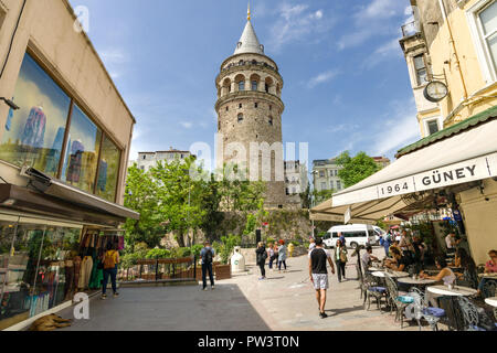 Torre di Galata domina lo skyline come persone sedersi fuori in una caffetteria locale su una soleggiata giornata di primavera, Istanbul, Turchia Foto Stock