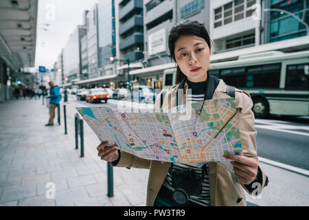 Bellissima femmina traveler tenendo la mappa e trovare la giusta direzione torna all hotel in Giappone. backpacker travel in Kyoto lifestyle. femmina asiatica Foto Stock