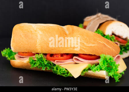 Grande panino con carne e formaggio su sfondo scuro. Foto Stock