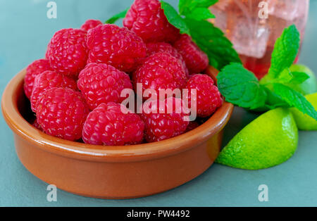 Un piatto di fresche e mature lamponi succosa, con la menta e lime Foto Stock