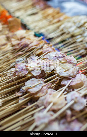 Close-up di bastoni di calamari a secco sulla strada del mercato in Thailandia. Tailandese tradizionale cibo di strada Foto Stock