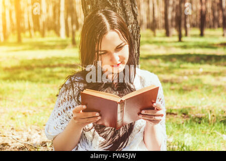 Donna lettura rilassante prenota al park Foto Stock