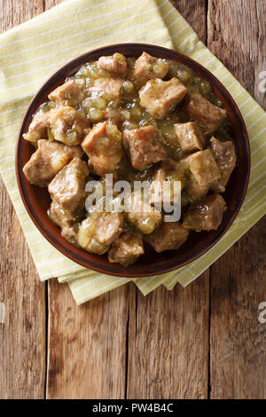 Questa autentica la carne di maiale cile verde ricetta. Offerta di pezzi di carne di maiale cotta lenta con una verde cile salsa (salsa verde) closeup sulla piastra. Verticale in alto vi Foto Stock