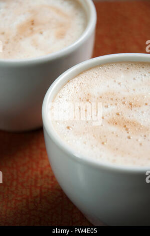 Con Tazza cappuccino con schiuma. Bevanda di caffè in tazze. Foto Stock