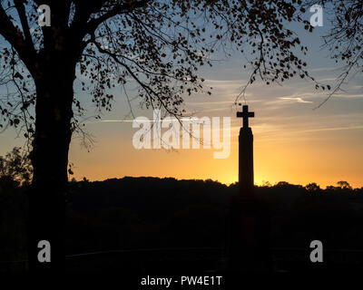 War Memorial cross stagliano contro un Cielo di tramonto il parco del castello a Knaresborough North Yorkshire, Inghilterra Foto Stock