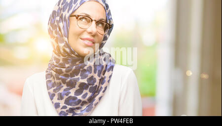 La mezza età araba musulmana donna che indossa il hijab il pensiero e la ricerca di esprimere dubbi e meraviglia Foto Stock