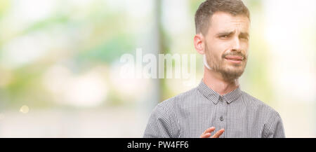 Giovane uomo parigamba disgustato espressione, orinato e timorosi facendo il disgusto di fronte perché la reazione di avversione. Con le mani alzate. Concetto di fastidiosi. Foto Stock