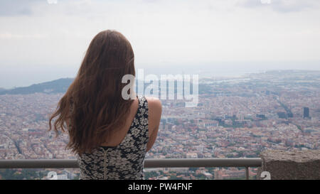 Ragazza di stare sulla piattaforma di osservazione. Barcelona city vista aerea. Panoramica della città. Vista mozzafiato Foto Stock