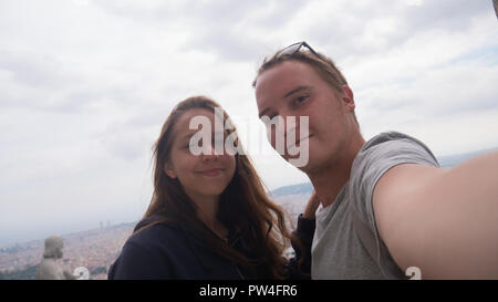 Una giovane coppia di prendere una selfie sulla piattaforma di osservazione. Barcelona city vista aerea. Panoramica della città. Foto Stock