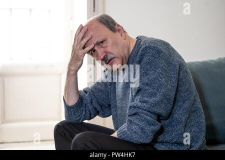 Senior vecchio uomo sensazione disperata triste guardando preoccupato premuto riflessivo e solitaria sul lettino a casa in invecchiamento della salute mentale problemi personali e Lif Foto Stock