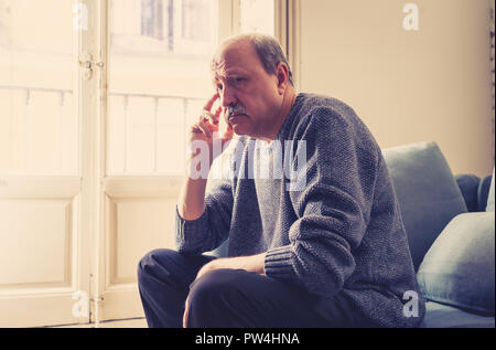 Senior vecchio uomo sensazione disperata triste guardando preoccupato premuto riflessivo e solitaria sul lettino a casa in invecchiamento della salute mentale problemi personali e Lif Foto Stock