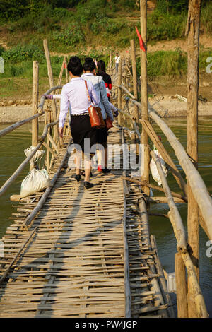 Frauen überqueren temporäre Bambusbrücke über den Nam Khan Fluß, Luang Prabang, Laos Foto Stock