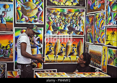 I giovani africani a parlare e ridere in loro tribale africana print shop presso il Victoria and Alfred Waterfront di Città del Capo in Sud Africa Foto Stock