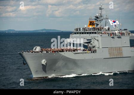 181011-N-DK042-0195 ACQUE AL LARGO DELLA PENISOLA COREANA (ott. 11, 2018) Una folla sulla Repubblica di Corea (ROK) navy sbarco nave cisterna Ilchulbong (LST 688) osserva multinazionale di navi durante una passata in rassegna come parte della Repubblica di Corea flotta internazionale di revisione (IFR) 2018. IFR 2018 è ospitato dalla Repubblica di Corea Navy per aiutare a migliorare la reciproca fiducia e confidenza con le marine di tutto il mondo. La distribuita portaerei USS Ronald Reagan CVN (76) è distribuita negli Stati Uniti 7 flotta area di operazioni a sostegno della sicurezza e della stabilità nella regione Indo-Pacifico. (U.S Foto Stock